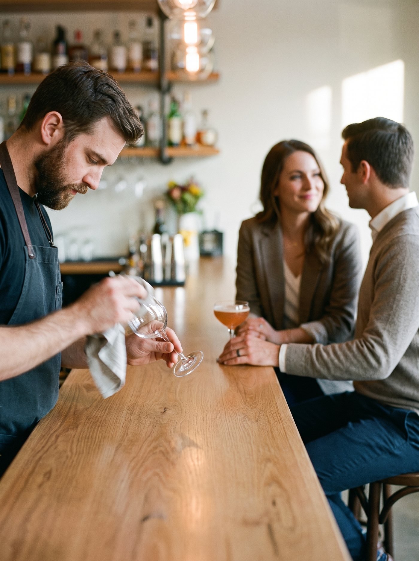 Dunkle, warm beleuchtete Bar mit hinterleuchteten Flaschen